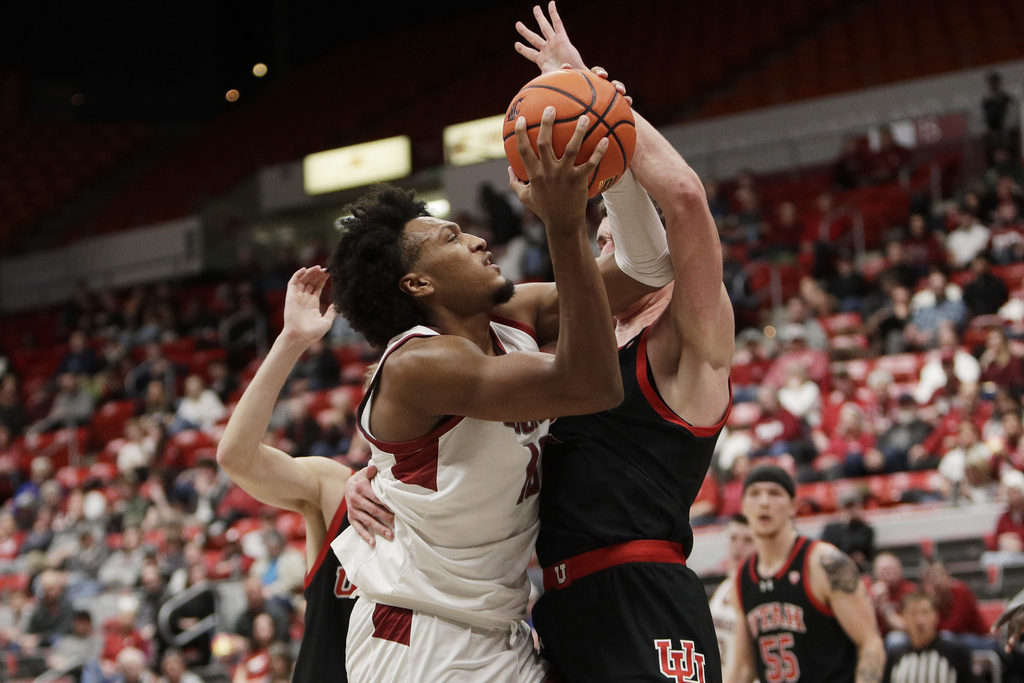 Washington State forward Isaac Jones, left, drives to the basket against Utah forward Ben Carlson during the second half of an NCAA college basketball game Wednesday, Jan. 24, 2024, in Pullman, Wash.