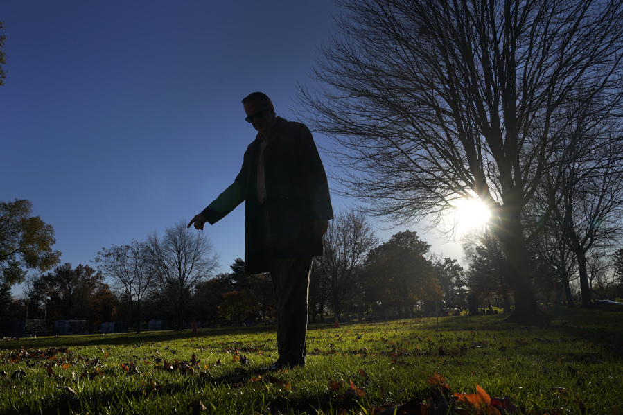 Cook County, Ill., Sheriff&rsquo;s Commander Jason Moran, who leads the sheriff&rsquo;s missing persons initiative stands in silhouette and points to a round cylinder that marks a grave of a person who self-identified as Seven, at the Mount Olivet Cemetery on Chicago&rsquo;s Far South Side Monday, Nov. 13, 2023. &ldquo;That&rsquo;s a horrible circumstance that someone could die and no one knows who they are. That&rsquo;s why we pursue these cases so strongly, out of dignity,&rdquo; says Moran, who oversees the sheriff&rsquo;s missing persons unit.