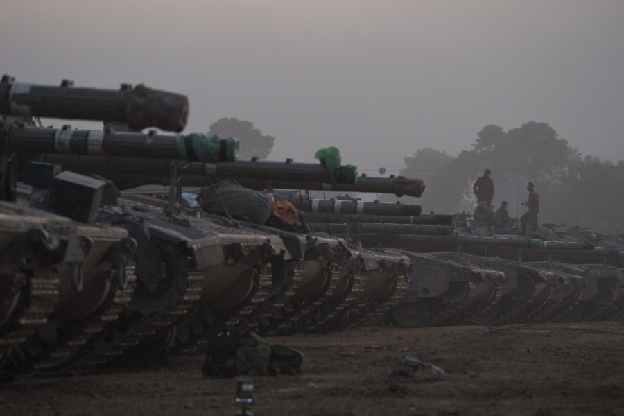 Israeli soldiers stand on top of a tank in a staging area at the Israeli-Gaza border in southern Israel, Monday, Jan. 1, 2024. The army is battling Palestinian militants across Gaza in the war ignited by Hamas&rsquo; Oct. 7 attack into Israel.