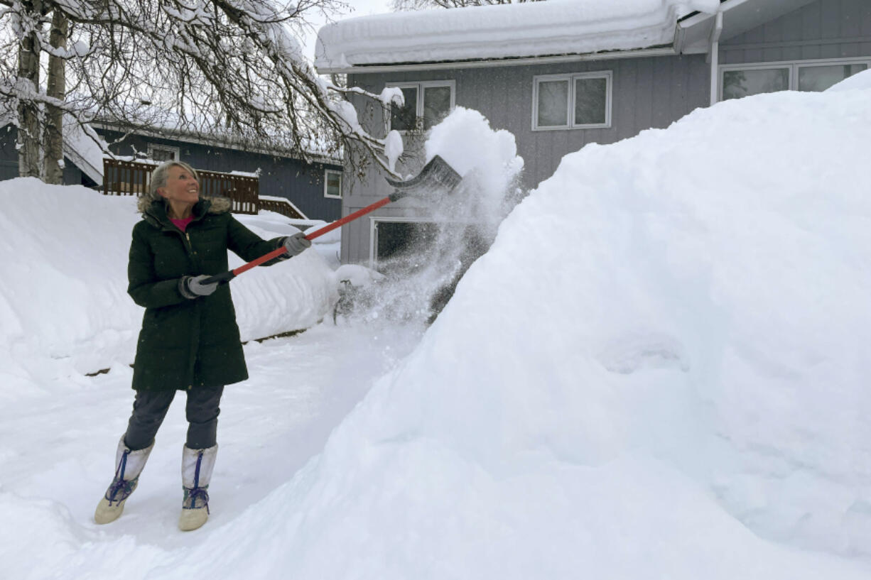Tamera Flores shovels snow off her driveway, Monday, Jan. 29, 2024, in Anchorage Alaska.