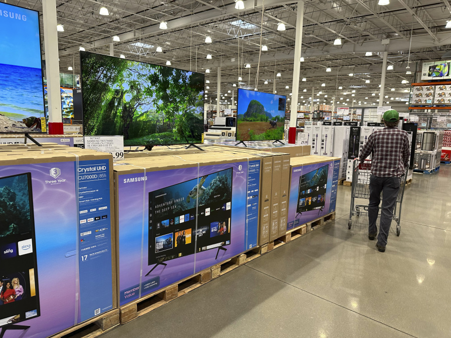 Shopper passes by display of big-screen televisions in a Costco warehouse Thursday, Jan. 11, 2024, in Sheridan, Colo.