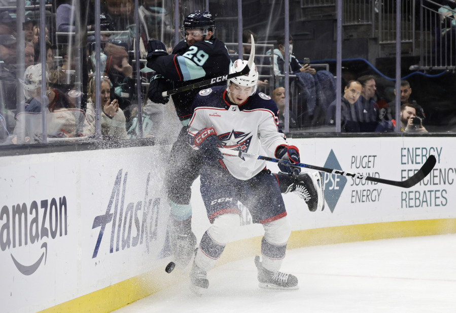 Seattle Kraken defenseman Vince Dunn (29) is checked by Columbus Blue Jackets right wing Yegor Chinakhov (59) during the second period of an NHL hockey game, Sunday, Jan. 28, 2024, in Seattle.