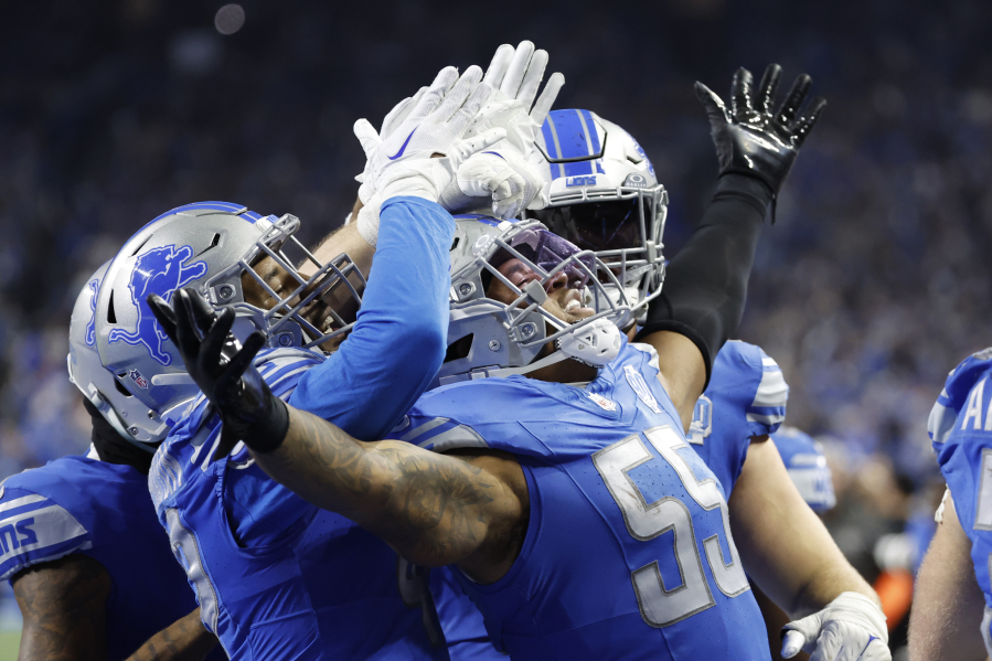 Detroit Lions linebacker Derrick Barnes (55) receives congratulations from teammates after he makes an interception in the fourth quarter against the Tampa Bay Buccaneers during an NFL divisional round playoff football game Sunday, Jan. 21, 2024, in Detroit.