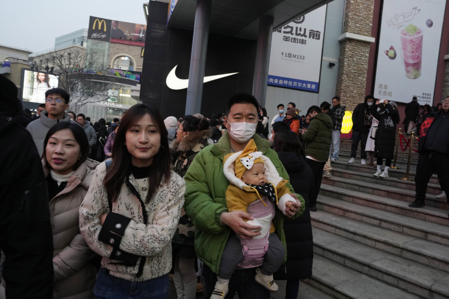 A man carries a child at a shopping mall in Beijing, Dec. 30, 2023. China&rsquo;s population dropped by 2 million people in 2023 in the second straight annual drop as births fell and deaths jumped.