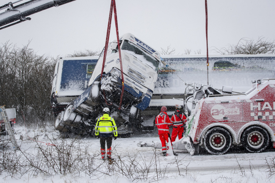 Rescuers try to recover a truck that slided off road during a heavy snowfall in Viborg, central Jutland, Denmark, Wednesday Jan. 3, 2024. Temperatures have fallen below minus 40 degrees Celsius in the Nordic region for a second day in a row, with the coldest January temperature recorded in Swedish Lapland in 25 years. The weather -&ndash; cold with snow and gale-force winds -- has disrupted transportation throughout the Nordic region, with several bridges closed and some train and ferry services suspended.