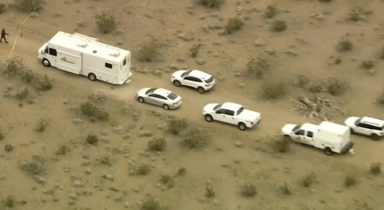 This aerial still image from video provided by KTLA shows law enforcement vehicles where several people were found shot to death in El Mirage, Calif. on Wednesday, Jan. 24, 2024. Deputies found the bodies of six people at a remote dirt crossroads in the Mojave Desert in Southern California, a scene described as so grisly that TV stations blurred some of the images captured by their helicopter overhead.