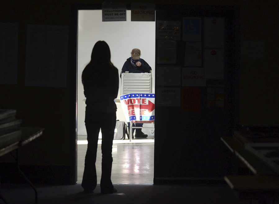 FILE - A first-time voter waits in the doorway for a voting booth as another voter completes his ballot at the Boot City Opry near Terre Haute, Ind., Nov. 3, 2020. (Joseph C.