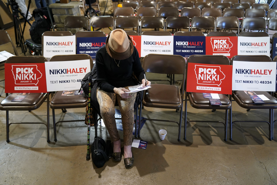 Sandra Sandfort, of Ames, Iowa, signs a commit to caucus card before a Republican presidential candidate Nikki Haley town hall, Monday, Dec. 18, 2023, in Nevada, Iowa.