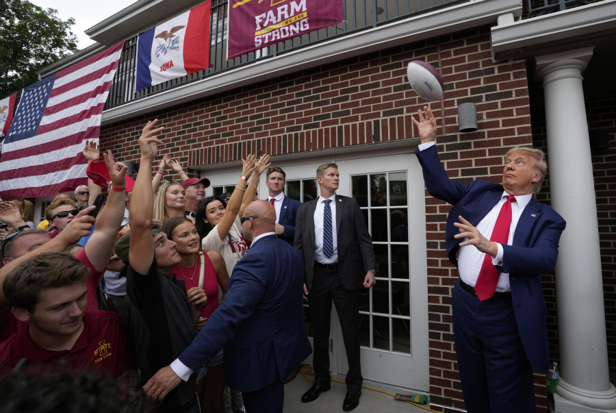 FILE - Former President Donald Trump throws a football to the crowd during a visit to the Alpha Gamma Rho fraternity, at Iowa State University before an NCAA college football game between Iowa State and Iowa, Sept. 9, 2023, in Ames, Iowa. In 2024, Iowa will again hold the first Republican contest. Trump lost Iowa to Texas Sen. Ted Cruz in 2016, but then dominated in New Hampshire, South Carolina and Nevada.