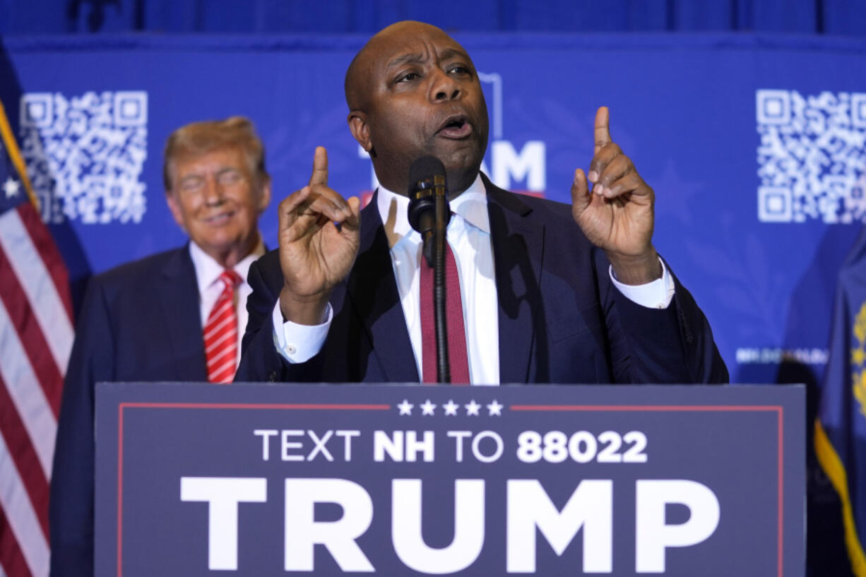 FILE - Republican presidential candidate former President Donald Trump, left, listens as Sen. Tim Scott, R-S.C., speaks at a campaign event in Concord, N.H., Jan. 19, 2024. Black voters support the reelection of President Joe Biden at a surprisingly low level, according to recent AP polling. For Republican strategists and former President Donald Trump, that&rsquo;s an opportunity to make inroads into the Democratic Party&rsquo;s most loyal voting bloc. Both parties are fine-tuning efforts to win over Black voters. Scott, who once challenged Trump for the GOP nomination, has emerged as one of his most prominent surrogates and speaks often about his record on race.