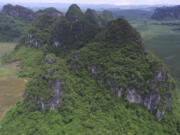 This photo provided by researchers shows a mountain where fossils of Gigantopithcus blacki were found in caves in the Guangxi region of southern China. The extinct species of great ape that once stood around 10 feet tall and weighed up to 650 pounds was likely driven to extinction by environmental changes, scientists in China and Australia report on Wednesday, Jan. 10, 2024 in the journal Nature.