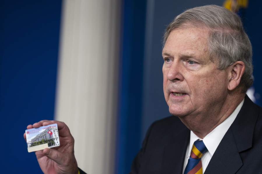 FILE - Agriculture Secretary Tom Vilsack holds up a Supplemental Nutrition Assistance Program Electronic Benefits Transfer (SNAP EBT) card during a news conference at the White House, Wednesday, May 5, 2021, in Washington. Nearly 21 million children in the U.S. and its territories are expected to receive food benefits this summer through a newly permanent federal program, the United States Department of Agriculture announced Wednesday, Jan. 10, 2024. &ldquo;No child in this country should go hungry,&rdquo; Vilsack said in an interview on Tuesday.