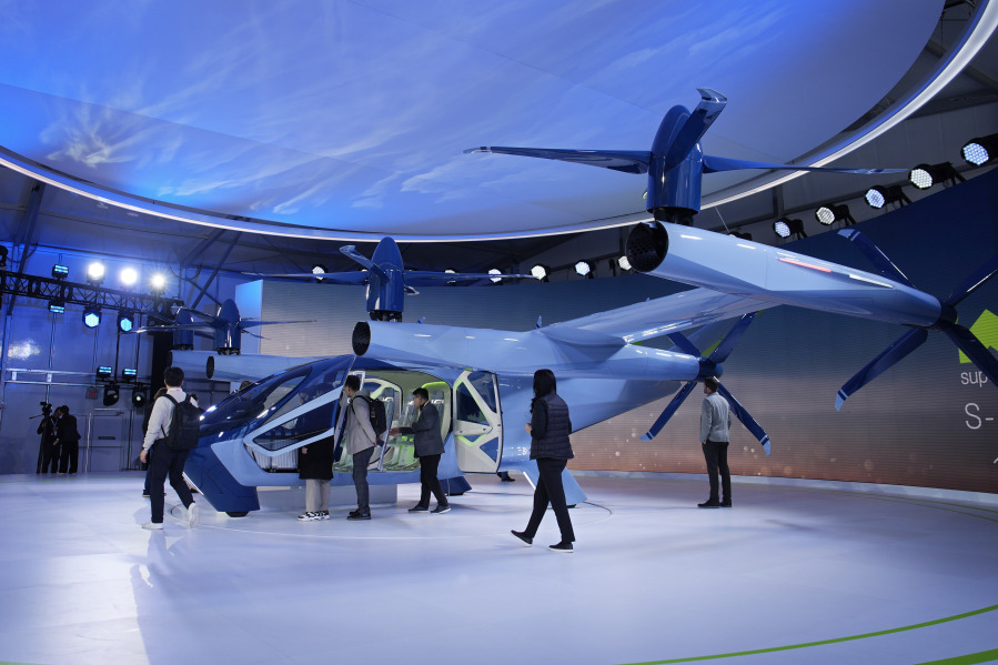 People look at the Supernal S-A2 passenger electric VOTL aircraft at the Supernal booth Wednesday. Supernal is a part of the Hyundai Motor Group.
