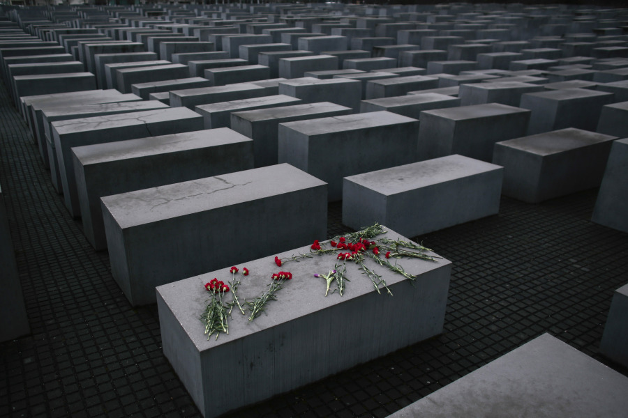 FILE - Flowers lie on a concrete slab of the Holocaust Memorial to mark the International Holocaust Remembrance Day and commemorating the 70th anniversary of the liberation of the Nazi Auschwitz death camp in Berlin, Jan. 27, 2015. Almost 80 years after the Holocaust, about 245,000 Jewish survivors are still living across more than 90 countries, according to the report by the New York-based Conference on Jewish Material Claims Against Germany.