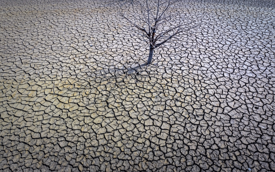 FILE - The cracked earth of the Sau reservoir is visible north of Barcelona, Spain, March 20, 2023. Earth last year shattered global annual heat records, the European climate agency said Tuesday, Jan. 9, 2024.