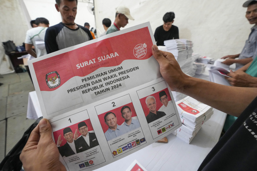 A worker holds a ballot for the Feb. 14 presidential election showing candidates, from left, Anies Baswedan and his running mate Muhaimin Iskandar, Prabowo Subianto and running mate Gibran Rakabuming Raka, and Ganjar Pranowo and his running mate Mahfud MD, during the preparation for the distribution of election logistics in Tangerang, Indonesia Wednesday, Jan. 10, 2024. The world&rsquo;s third-largest democracy is scheduled to hold its legislative and presidential elections on Feb. 14, 2024.