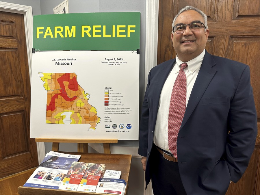 Missouri Treasurer Vivek Malek stands near a poster promoting drought conditions and state aid programs on Jan. 4, 2024, at his Capitol office in Jefferson City, Mo. Agricultural entities are among several categories of businesses that can receive low-interest loans backed by deposits of state funds made by the treasurer&rsquo;s office. Participation in such programs has grown in various states. (AP Photo/David A.