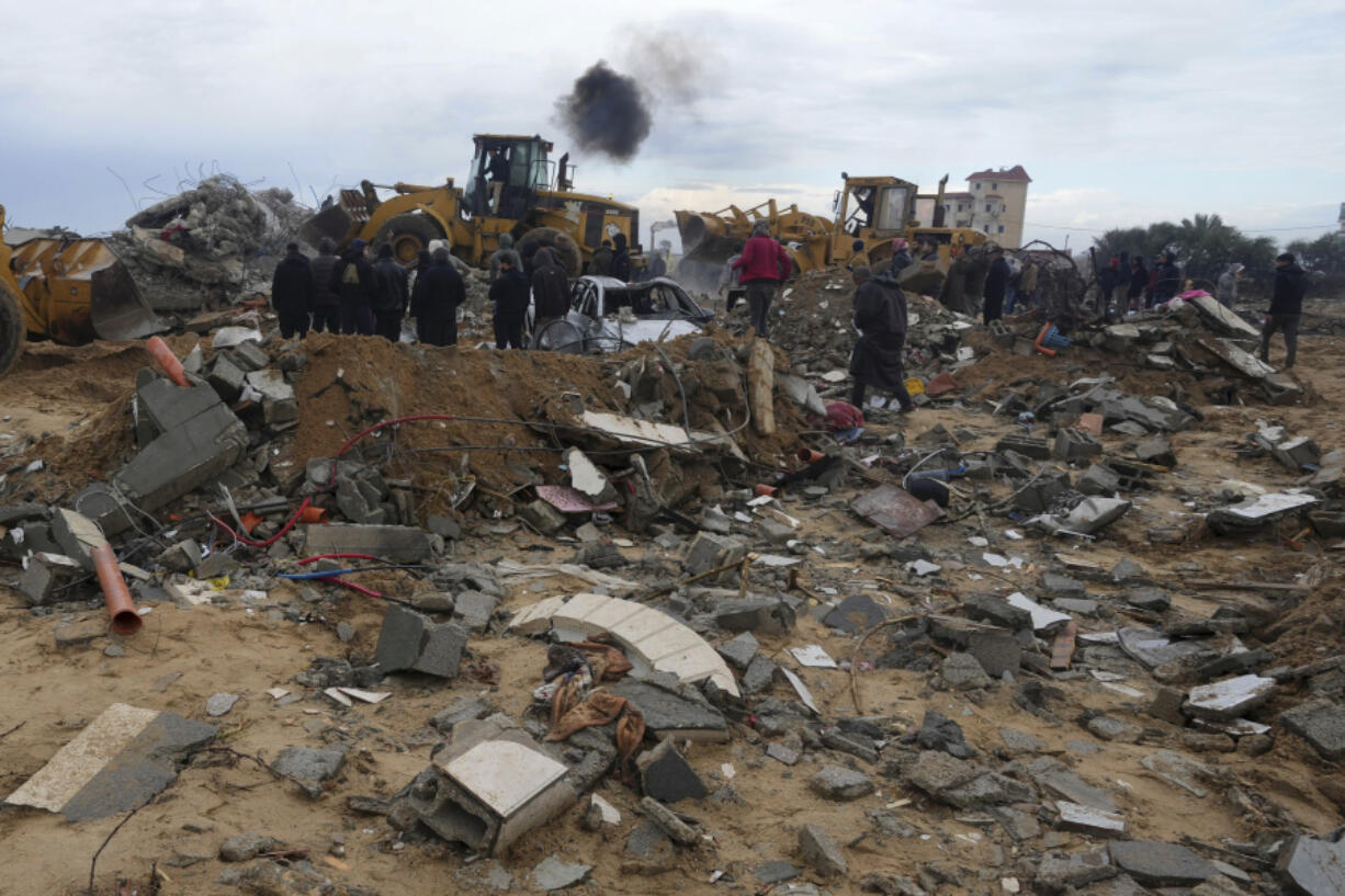 Palestinians search for the bodies after an Israeli strike in Zuweida, Gaza Strip, Monday, Jan. 29, 2024.