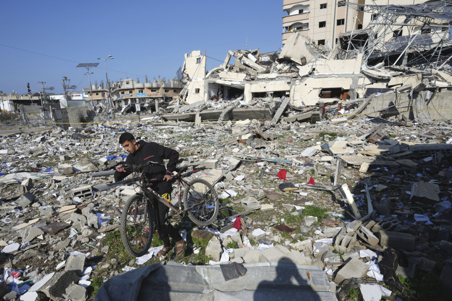 A Palestinian walks through the destruction by the Israeli bombardment in the Nusseirat refugee camp in Gaza Strip, Tuesday.
