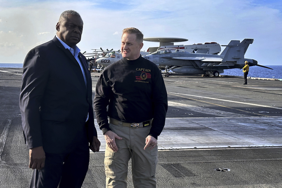 Defense Secretary Lloyd Austin, left, talks with the commanding officer of the USS Gerald R. Ford, Navy Capt. Rick Burgess, during an unannounced visit to the ship on Wednesday, Dec. 20, 2023. The USS Gerald R. Ford has been sailing just a few hundred miles off the coast of Israel to prevent the Israel-Hamas war from expanding into a regional conflict.