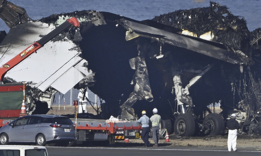 A removal work is underway at the site of a planes collision at Haneda airport in Tokyo Friday, Jan. 5, 2024. Cranes were dismantling the Japan Airlines Flight 516 Airbus A350 that caught fire after hitting a Coast Guard aircraft while it was landing Tuesday at the airport.