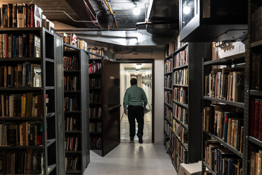 An employee walks through a library at the headquarters of the John Birch Society in Appleton, Wis., on Nov. 17, 2022.
