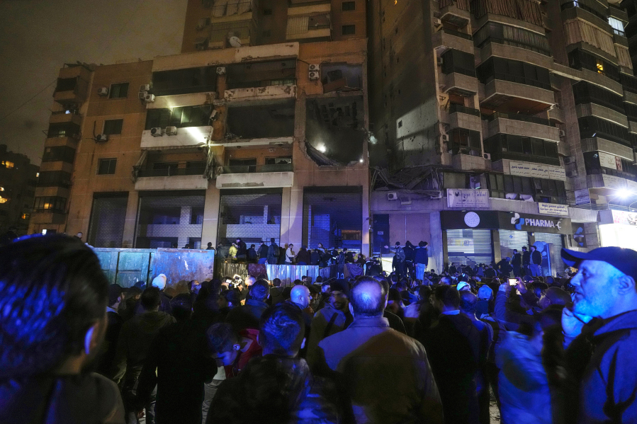 People search for survivors inside an apartment following a massive explosion in the southern suburb of Beirut, Lebanon, Tuesday, Jan. 2, 2024.