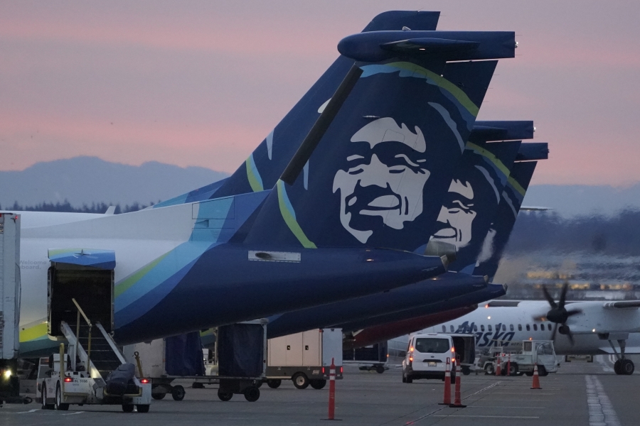 FILE - Alaska Airlines planes are shown parked at gates at sunrise, March 1, 2021, at Seattle-Tacoma International Airport in Seattle. An Alaska Airlines flight made an emergency landing in Oregon on Friday, Jan. 5, 2024, after a window and chunk of its fuselage blew out in mid-air, media reports said. (AP Photo/Ted S.