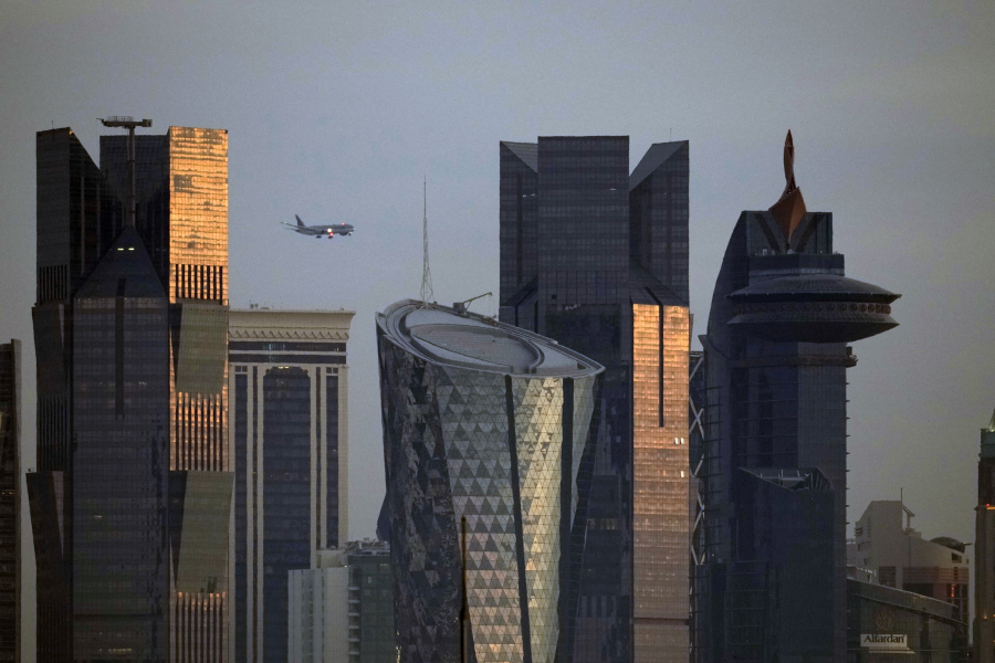 An aircraft flying near skyscrapers of West Bay, approaches the Hamad International Airport in Doha, Qatar, Thursday, Jan. 25, 2024.