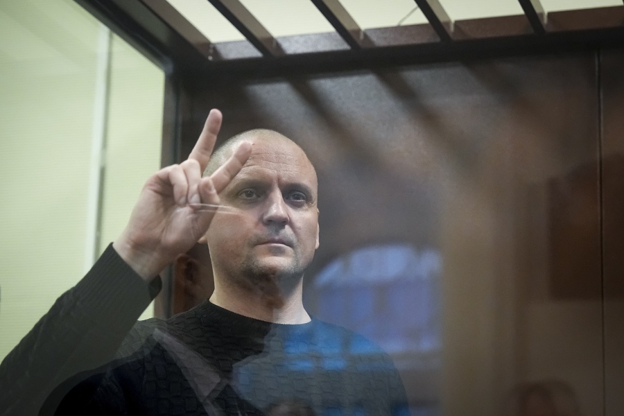 Sergei Udaltsov, Russian left-wing political activist, gestures standing behind a glass in a cage in a courtroom in Moscow, Russia, Friday, Jan. 12, 2024. A Russian state news agency says a Russian court has ordered that a pro-war activist and critic of President Vladimir Putin be remanded into custody until Feb. 15.