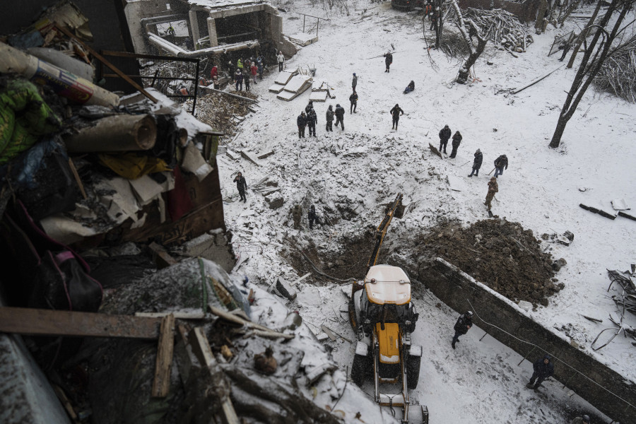 Volunteers and municipal workers clear the rubble of a residential building which was heavily damaged yesterday by Russian attack in Kyiv, Ukraine, Wednesday, Jan. 3, 2024.