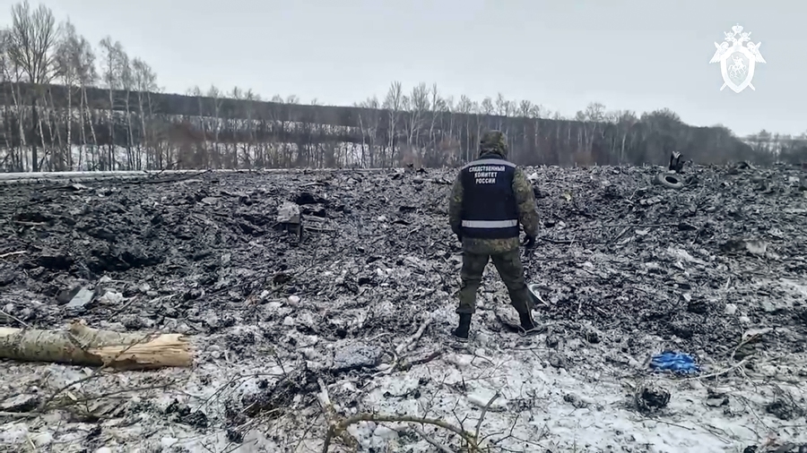 In this photo taken from video released by Russian Investigative Committee on Thursday, Jan. 25, 2024, A Russian Investigative Committee employee walks by the wreckage of the Il-76 near Yablonovo, Belgorod region of Russia, Thursday, Jan. 25, 2024. Russia and Ukraine are trading accusations over the crash of a military transport plane that Moscow said was carrying Ukrainian prisoners of war and was shot down by Kyiv&rsquo;s forces. The Il-76 crashed in a huge ball of fire in a rural area of Russia, and authorities there said all 74 people on board, including 65 POWs, six crew and three Russian servicemen, were killed.