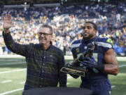 Seattle Seahawks linebacker Bobby Wagner, right, is presented with the Steve Largent award by former Seattle Seahawks player Steve Largent before an NFL football game against the Pittsburgh Steelers, Sunday, Dec. 31, 2023, in Seattle. The Steelers won 30-23.