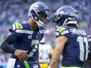 Seattle Seahawks quarterback Geno Smith, left, greets wide receiver Jaxon Smith-Njigba (11) after connecting for a touchdown against the Pittsburgh Steelers during the first half of an NFL football game Sunday, Dec. 31, 2023, in Seattle. The Steelers won 30-23.