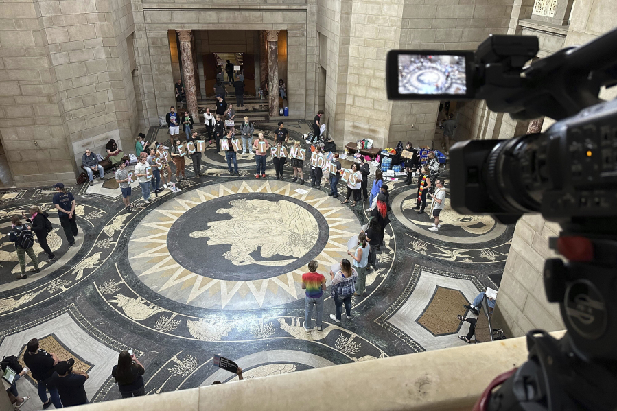 FILE - Protesters gather inside the State Capitol building on Friday, May 19, 2023, in Lincoln, Neb., before lawmakers were scheduled to begin debating a bill that will ban abortions at 12 weeks of pregnancy and also ban gender-affirming care for transgender minors.