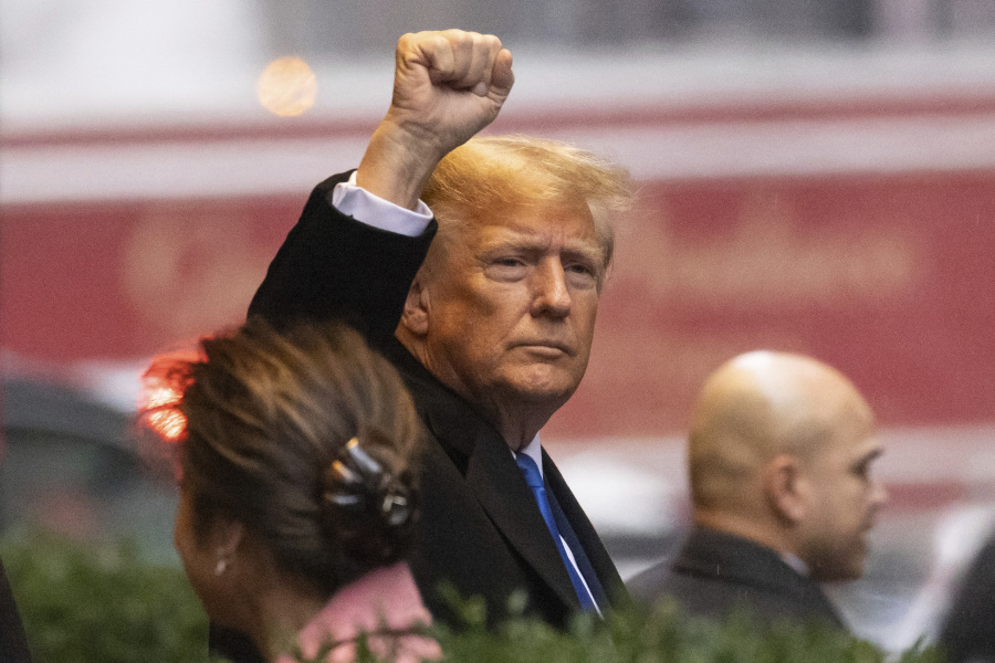 Former President Donald Trump raises his fist as he leaves his apartment building, Thursday, Jan 25, 2024, in New York.