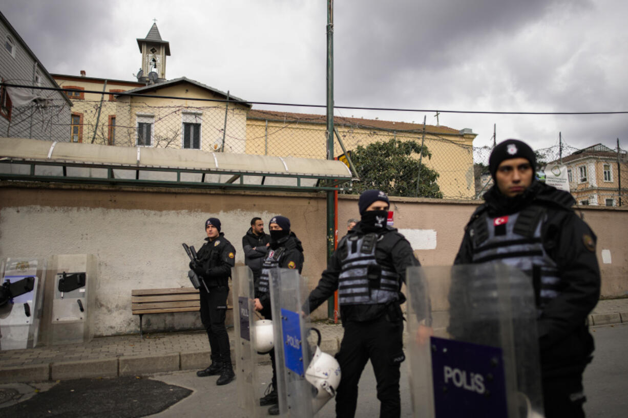 Turkish police officers stand guard in a cordoned off area outside the Santa Maria church, in Istanbul, Turkey, Sunday, Jan. 28, 2024. Two masked assailants attacked a church in Istanbul during Sunday services, killing one person, Turkish officials said.