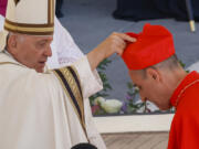 Newly elected Cardinal V&iacute;ctor Manuel Fern&aacute;ndez, Prefect of the Dicastery for the Doctrine of the Faith, right, receives his biretta from Pope Francis on Sept. 30, as he is elevated in St. Peter&rsquo;s Square at The Vatican.