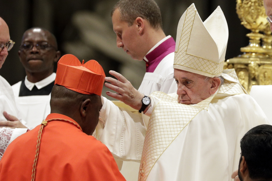FILE - Cardinal Fridolin Among Besungu receives the red three-cornered biretta hat from Pope Francis during a consistory inside St. Peter&rsquo;s Basilica, at the Vatican, Oct. 5, 2019. In the greatest rebuke of Pope Francis yet, the Catholic hierarchy of Africa and Madagascar issued a unified statement Thursday, Jan.
