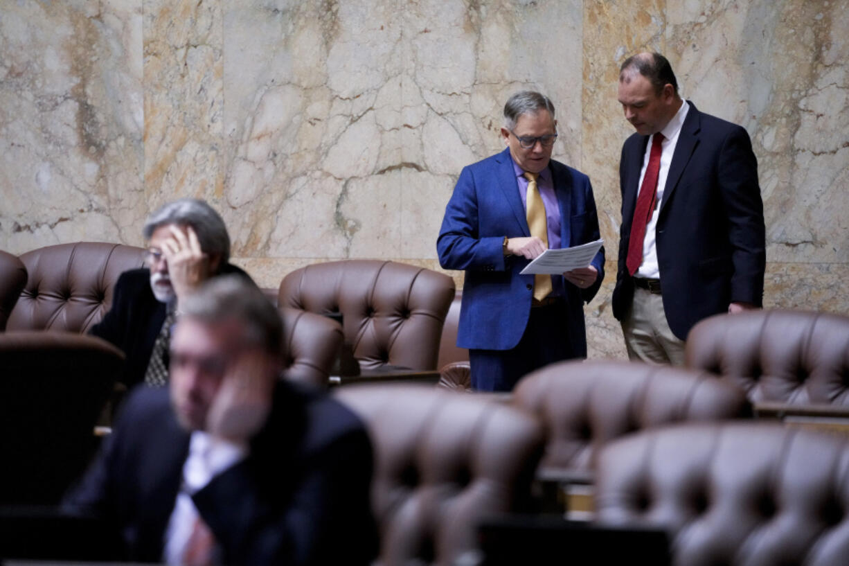 Rep. Bill Ramos, D-Issaquah, at left, talks with Rep. Greg Cheney, R-Battle Ground, in the House chambers on the first day of the legislative session at the Washington state Capitol Monday, Jan. 8, 2024, in Olympia, Wash.