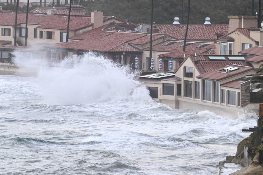 Waves crash into the windows of the Marine Room restaurant Tuesday, Jan. 23, 2024, in La Jolla, Calif. The restaurant is reinforced for the surf and no damage was done.  California Gov.