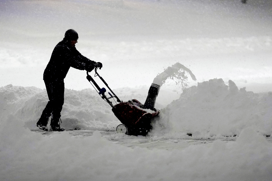 A local resident clears overnight snow from a driveway, Tuesday, Jan. 9, 2024, in Urbandale, Iowa.