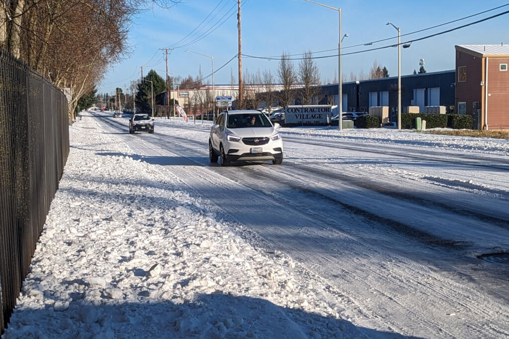 Drivers make their way down snowy streets on 121St Avenue in east Vancouver on Monday.