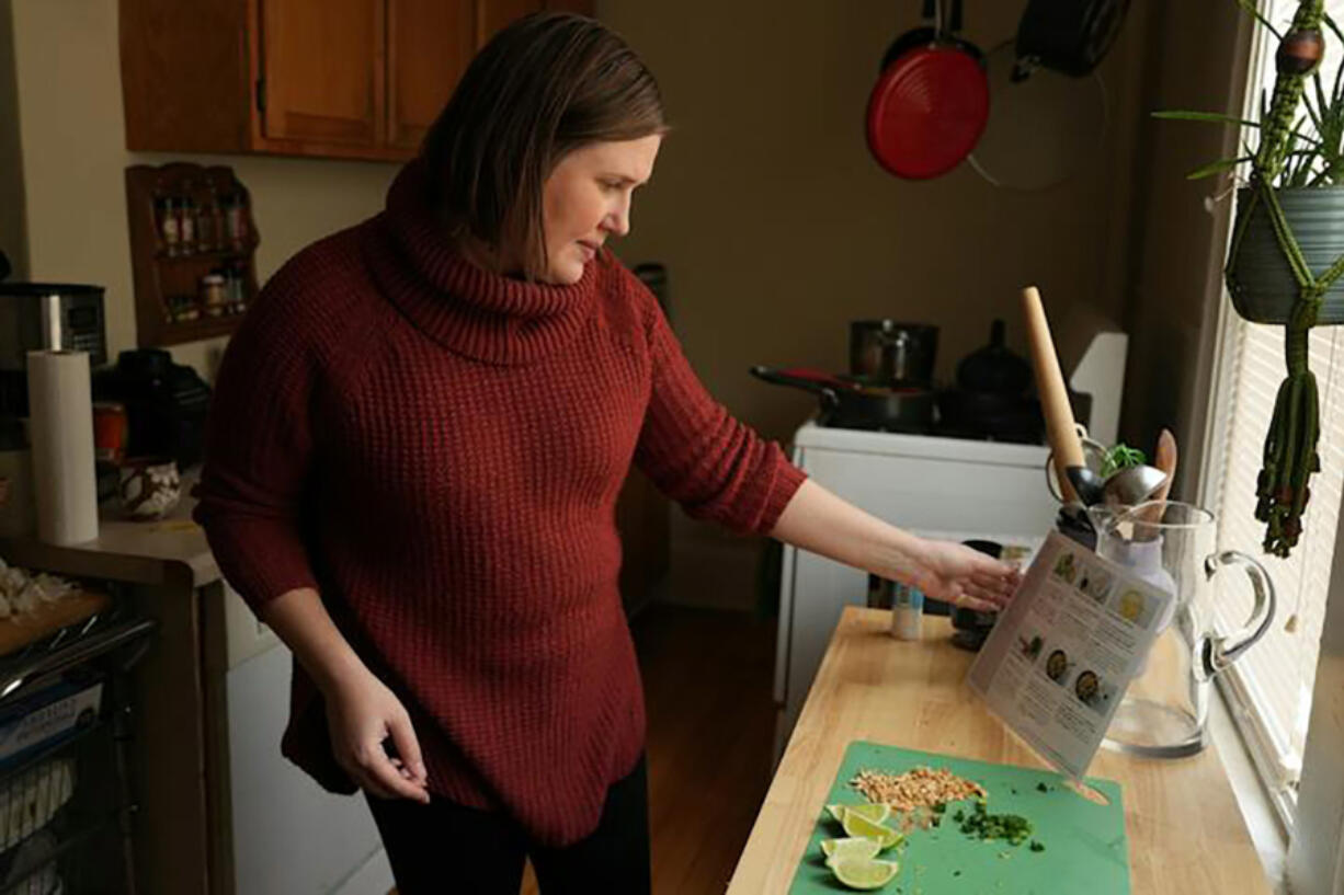 Jessica Bergman, a longtime Marley Spoon user, prepares one of the brand&rsquo;s meal kits of stir-fried curry rice noodles with Chinese broccoli and peanuts for lunch as she works from home.