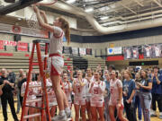Camas girls basketball senior Addison Harris cuts down a piece of the net after the Papermakers clinched the 4A Greater St. Helens League title with a win over Union on senior night Friday, Feb. 2, 2024, at Camas High School.