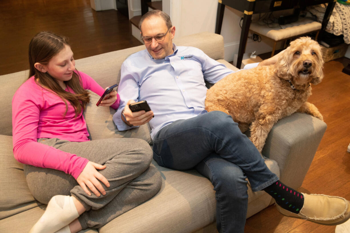 Will Fulmer, who owns an IT company, said he has had issues with cell service in and around his Bala Cynwyd, Pennsylvania, home for the past decade. He got so frustrated a year ago that he drove around and mapped the cell and data coverage in the region, showing dead spots. Will and his daughter, Shira, and dog, Max, are shown using their phones on Jan. 24, 2024.