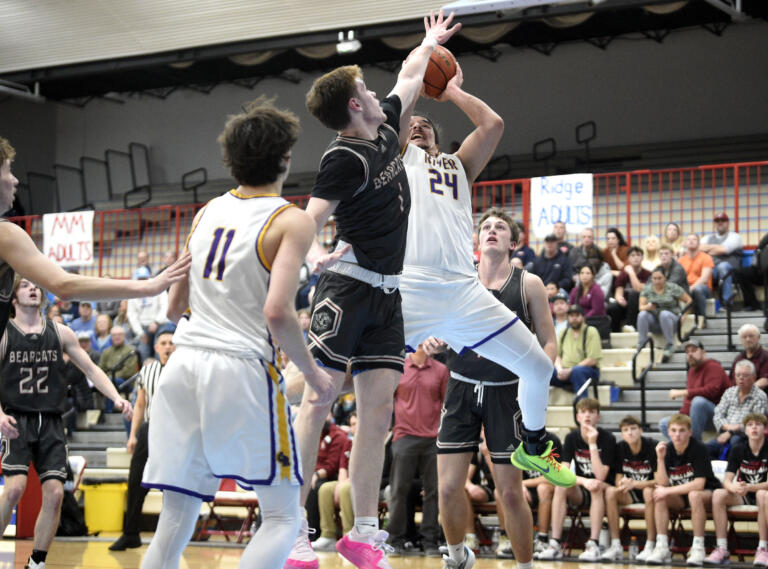 Columbia River’s Nico Valdez (24) attempts a shot over W.F. West’s Parker Eiswald (1) during a Class 2A District 4 boys basketball semifinal game on Tuesday, Feb. 13, 2024, at Mark Morris High School.