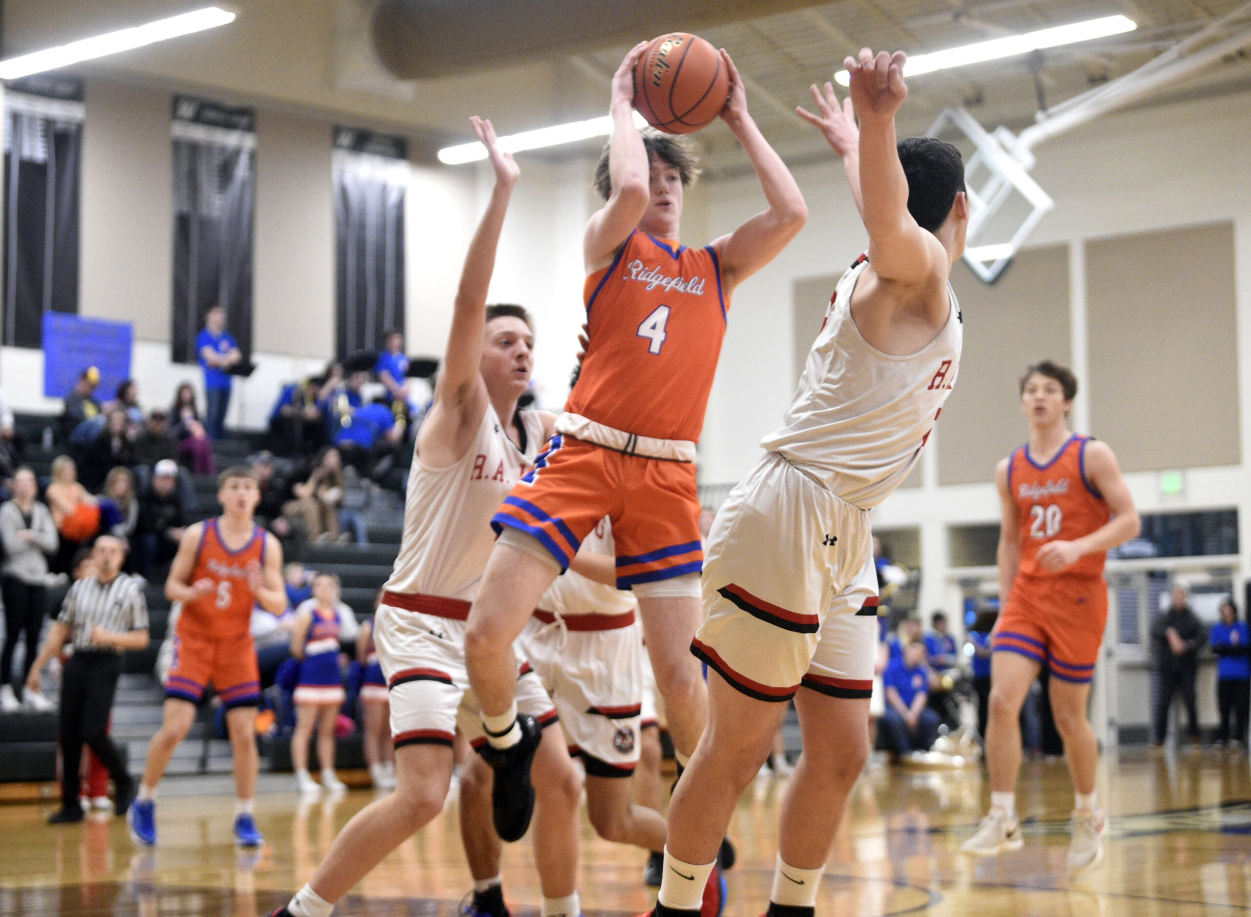 Ridgefield’s Cole Chester (4) looks to fire a pass to a teammate during a Class 2A District 4 winner-to-state boys basketball game against R.A. Long on Thursday, Feb. 15, 2024, at Woodland High School.