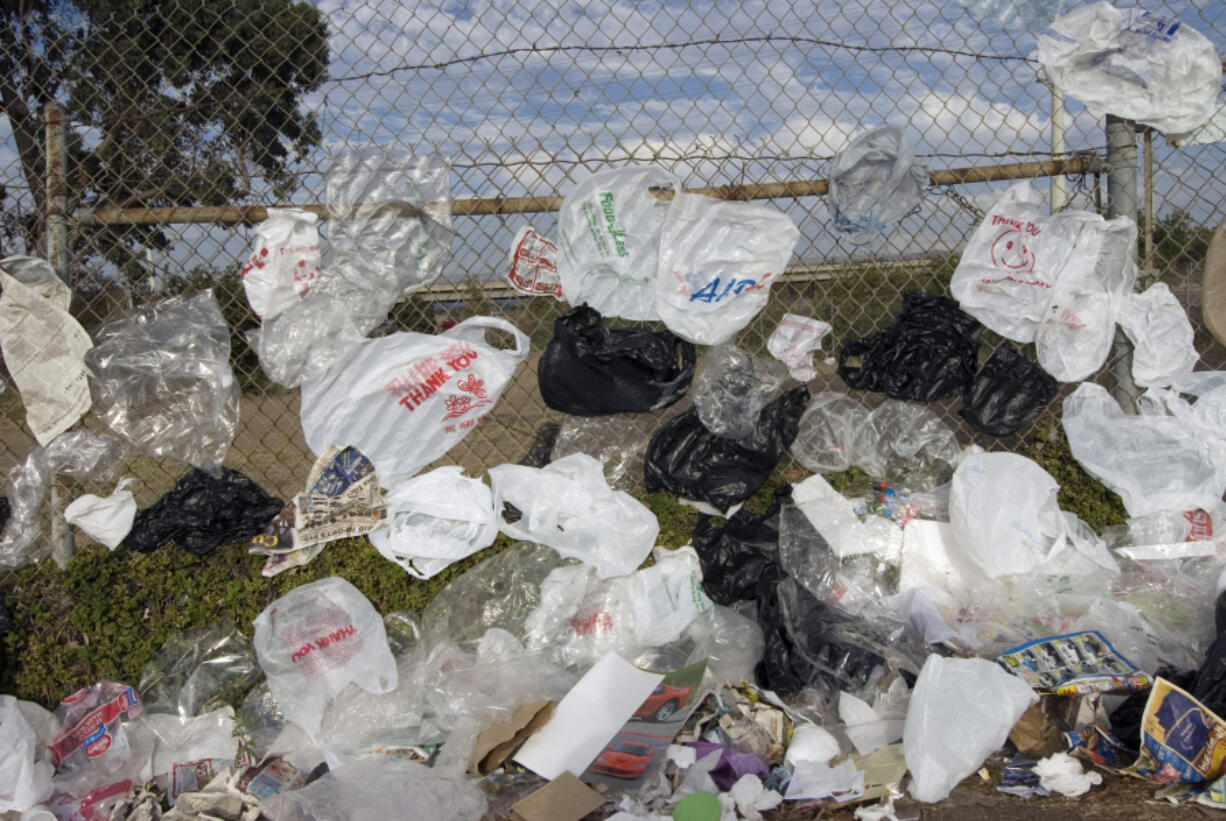 Plastic grocery bags line a chain link fence near a freeway in San Diego, in 2009. By 2022, the tonnage of discarded plastic bags had skyrocketed to 231,072 tons.  (Earl S.