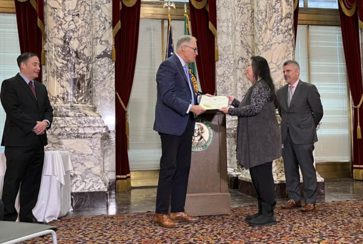 Gov. Jay Inslee presents Washington&rsquo;s Medal of Valor to Constance Chin Magorty, the sister of Donnie Chin, who founded the the International District Emergency Center in Seattle and died in a 2015 shooting. Secretary of State Steve Hobbs is to the left, and to the right is State Supreme Court Chief Justice Steven Gonzalez.